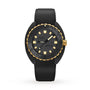 The DOXA Sub 300 Beta Sharkhunter is a black and gold wristwatch with a textured black dial, gold markers, a black rubber strap, and shows the time at 10:10.