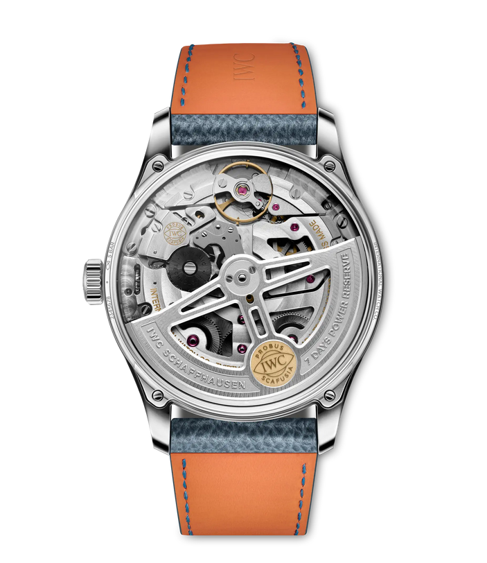The IWC Schaffhausen Portugieser Automatic 42 features chronometer precision, a silver case, blue textured leather strap with orange underside, and a transparent case back displaying its intricate internal mechanisms.