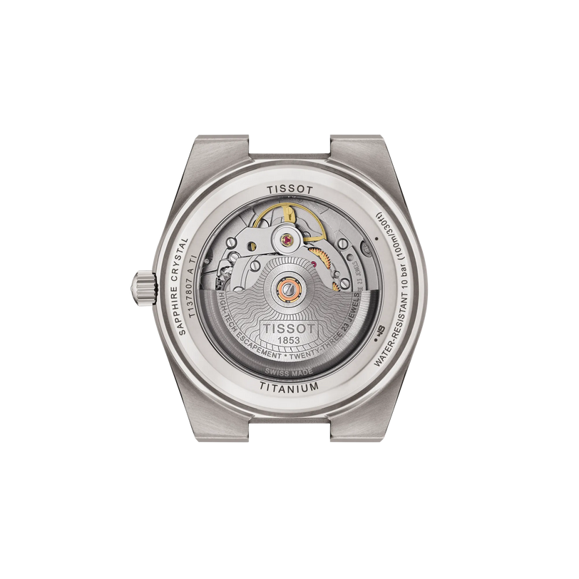Back view of the Tissot PRX 38 automatic: its titanium case showcases exposed movement through a sapphire crystal display, with brand, material details, and interchangeable bracelet features engraved on the edge.