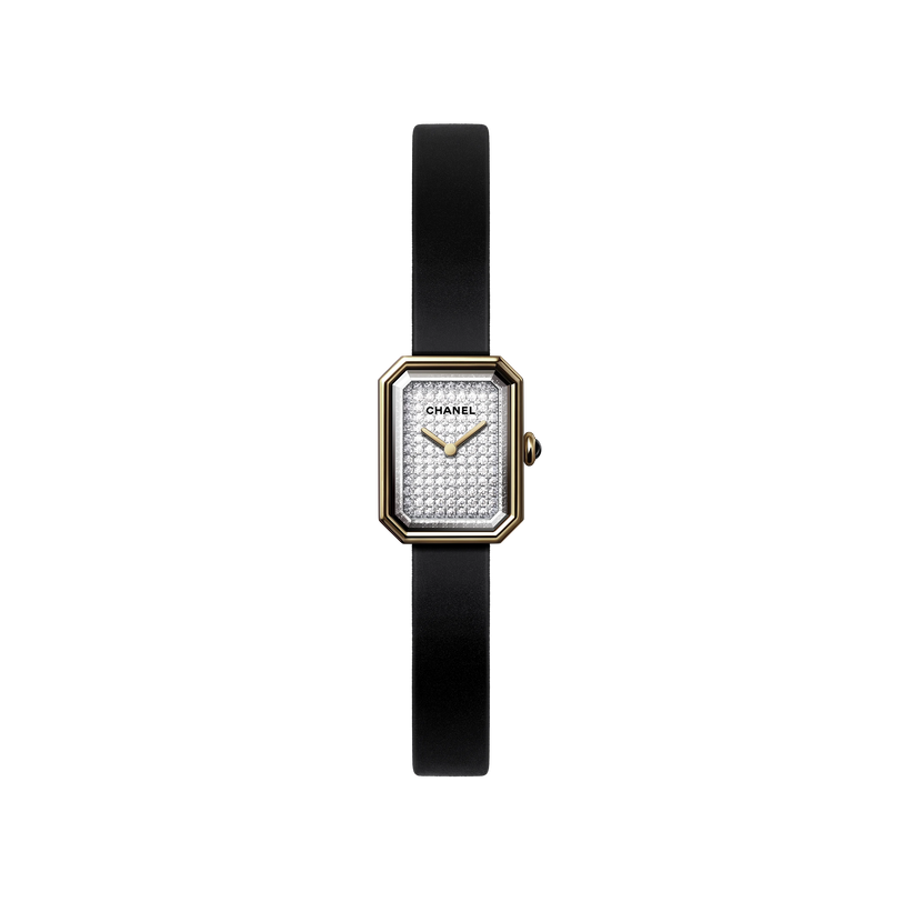 The Chanel Première Ribbon is a luxury women’s wristwatch featuring a slim black rubber strap, rectangular yellow gold-edged face, diamond dial, gold hands, and the iconic Chanel logo.