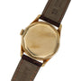 Patek Philippe Calatrava gold wristwatch with a plain, round case back and brown leather strap, shown from the back.