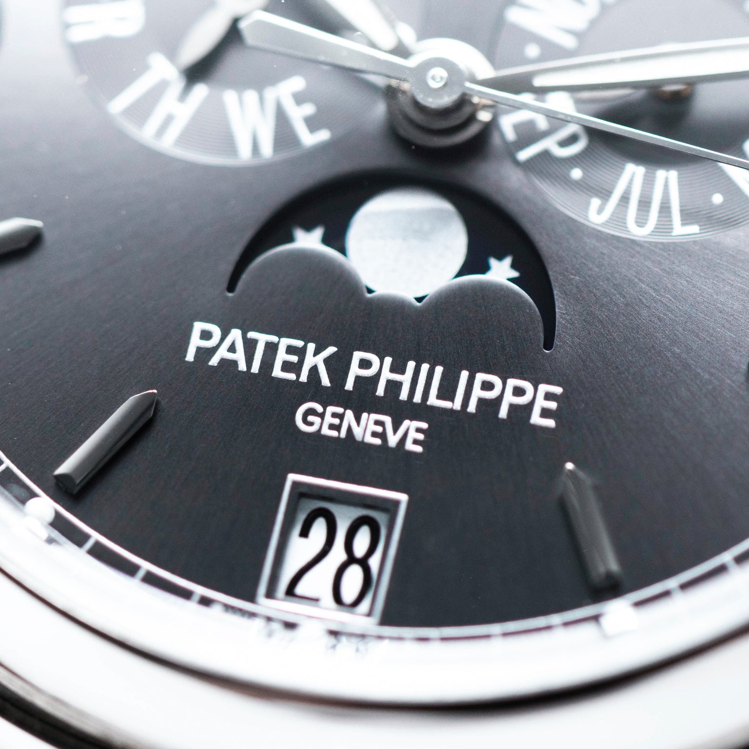 Close-up of the Patek Philippe Annual Calendar Moonphase watch face, featuring the moonphase indicator, brand logo, and date display.