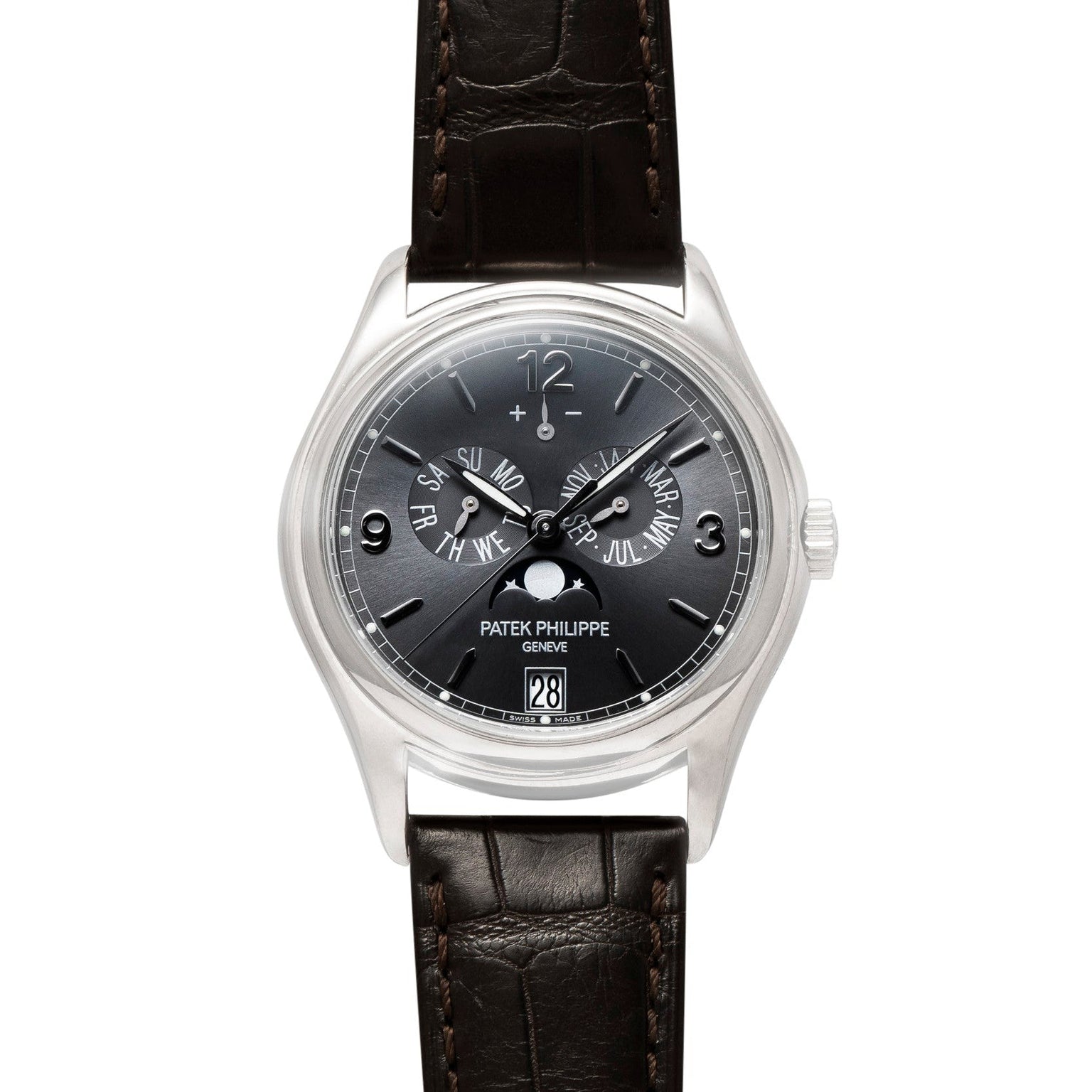 A Patek Philippe Annual Calendar Moonphase wristwatch featuring a black dial, silver case, and brown leather strap.