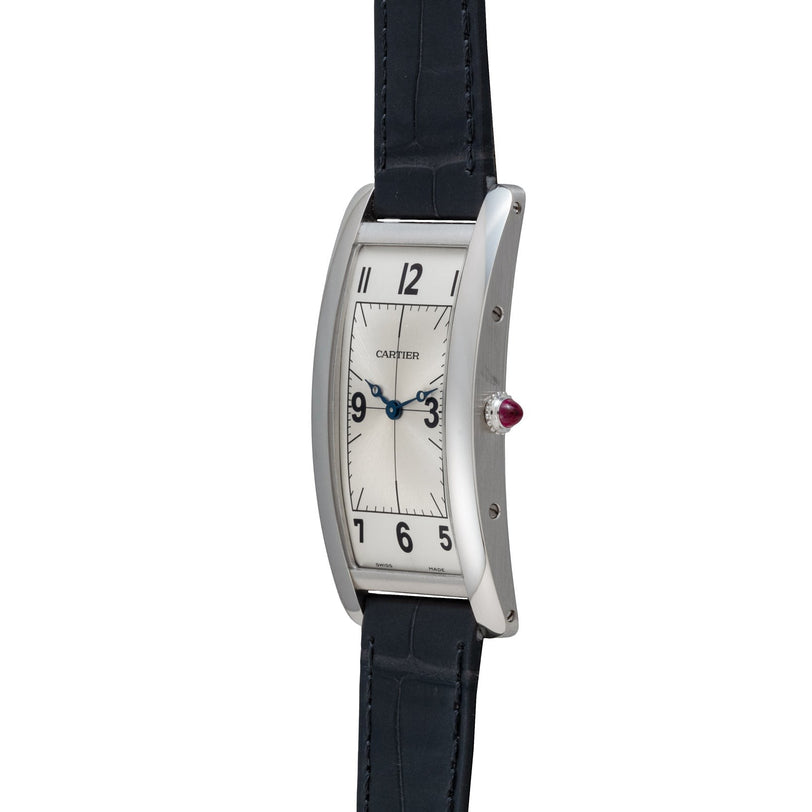 The Cartier Tank Cintrée Piece Unique is a rectangular wristwatch featuring a silver dial, black leather strap, and blue hands.