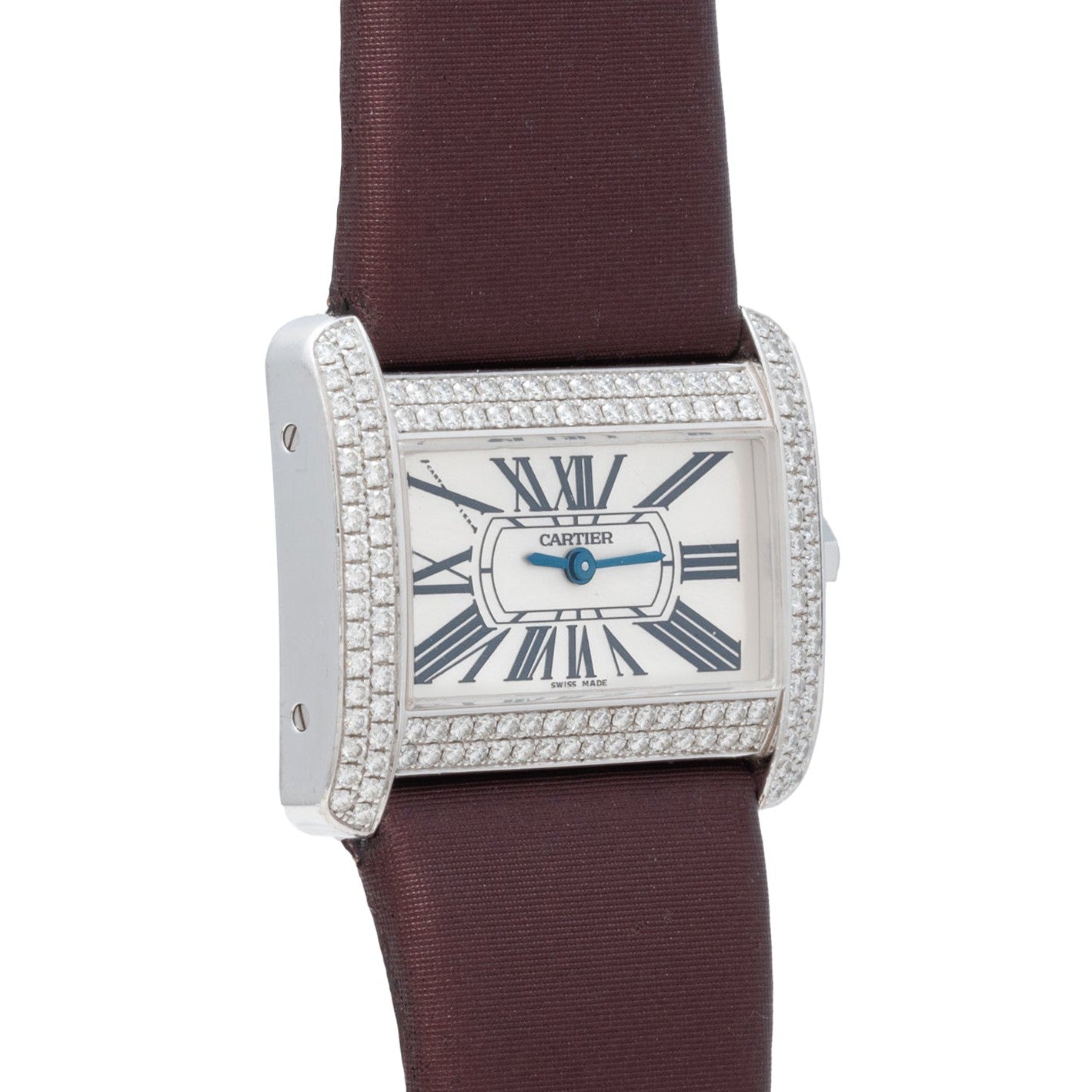 The Cartier Tank Divan is a luxury watch featuring a diamond bezel, Roman numeral markers, and a brown strap.