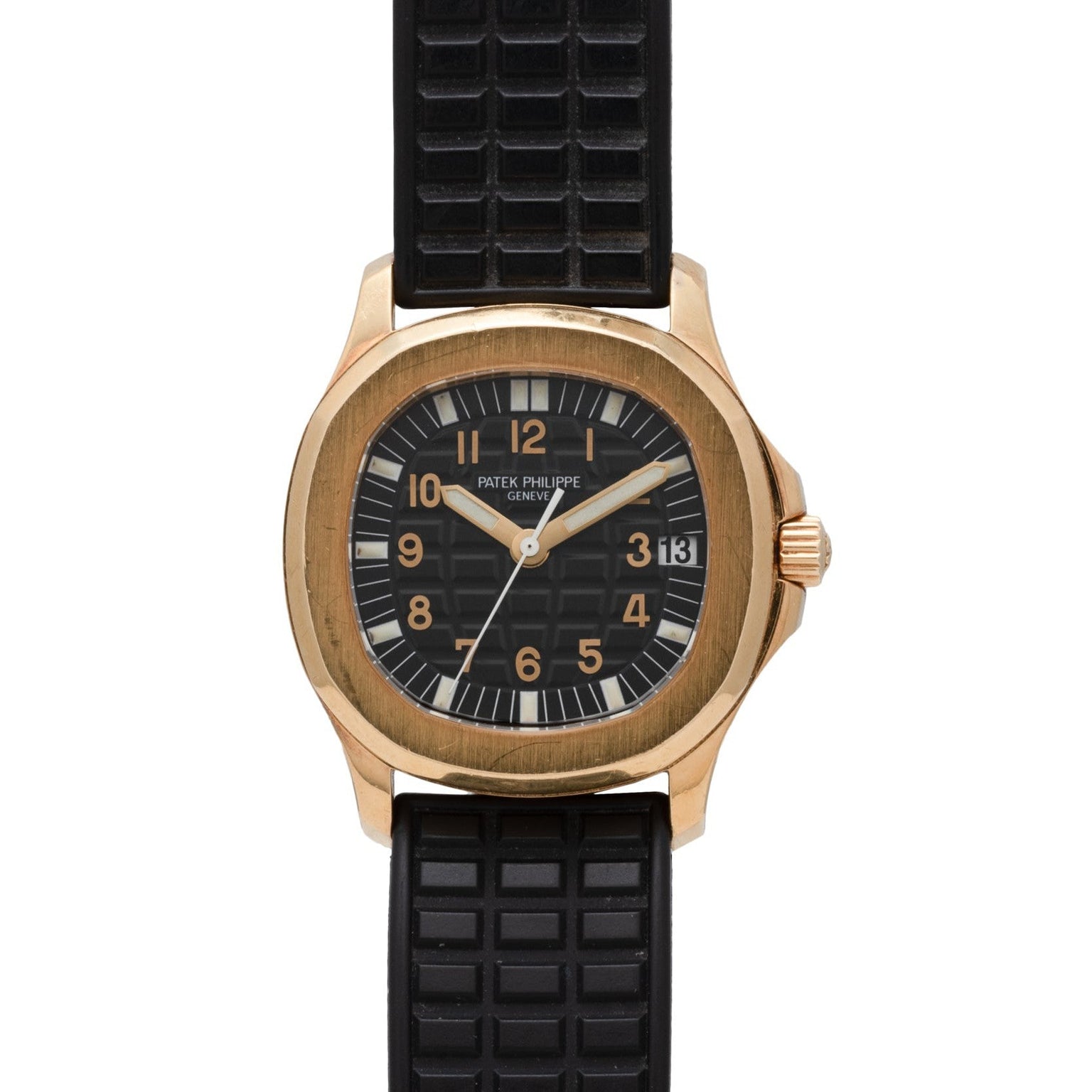 A Patek Philippe Aquanaut wristwatch in gold with a black dial, black textured rubber strap, and date display.