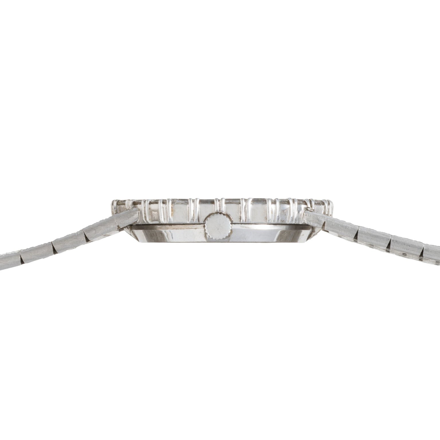 Side view of the Piaget Opal White Gold Dress Watch, featuring a slim profile, silver metal band, and ridged bezel.
