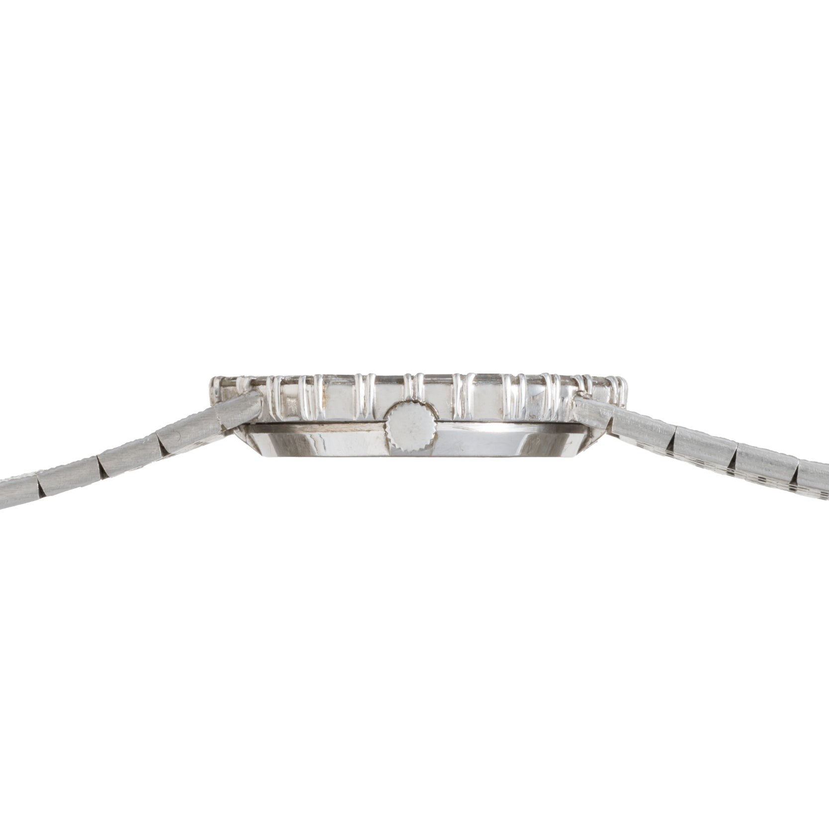 Side view of the Piaget Opal White Gold Dress Watch, featuring a slim profile, silver metal band, and ridged bezel.