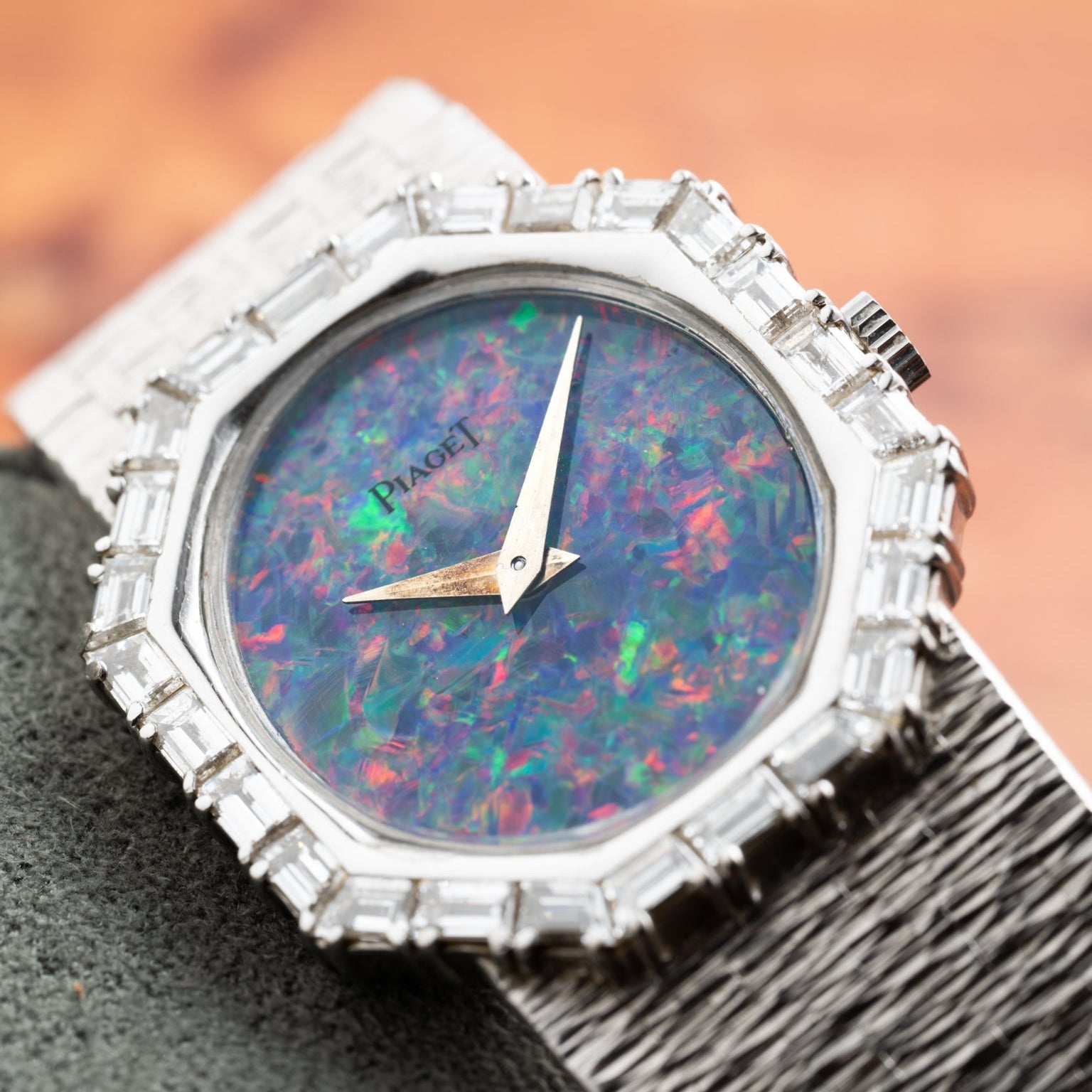 Close-up of Piagets Opal White Gold Dress Watch featuring a vibrant opal dial, diamond-set bezel, and a textured metal band.