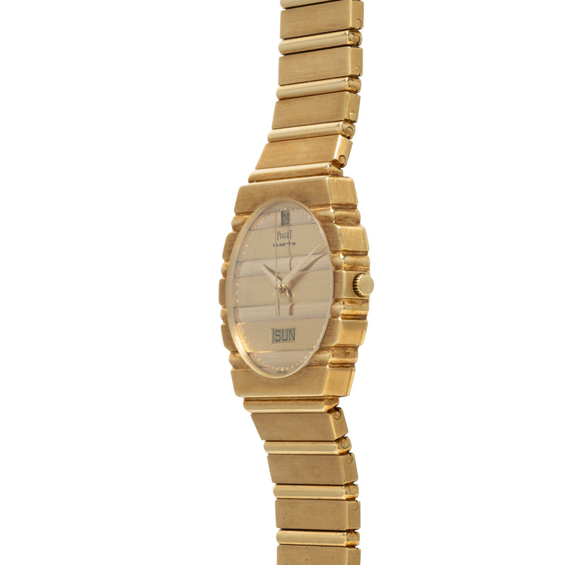 The Piaget Polo Calendar is a gold wristwatch with a rectangular face that shows the time and date, displayed against a white background.