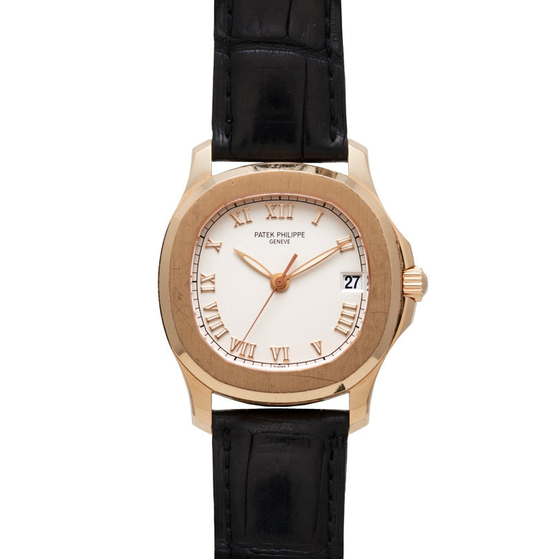 Patek Philippe Aquanaut watch with Roman numerals, black leather strap, and date display at 3 o’clock.