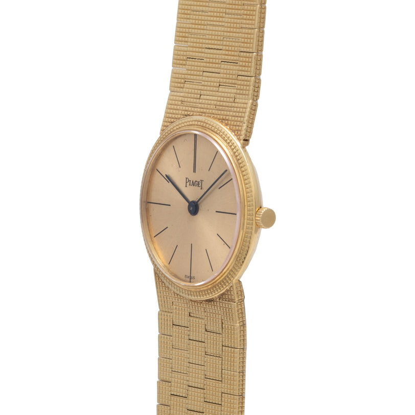 An 18K yellow gold Piaget dress watch with a textured band and minimalist gold dial, displayed at an angle.