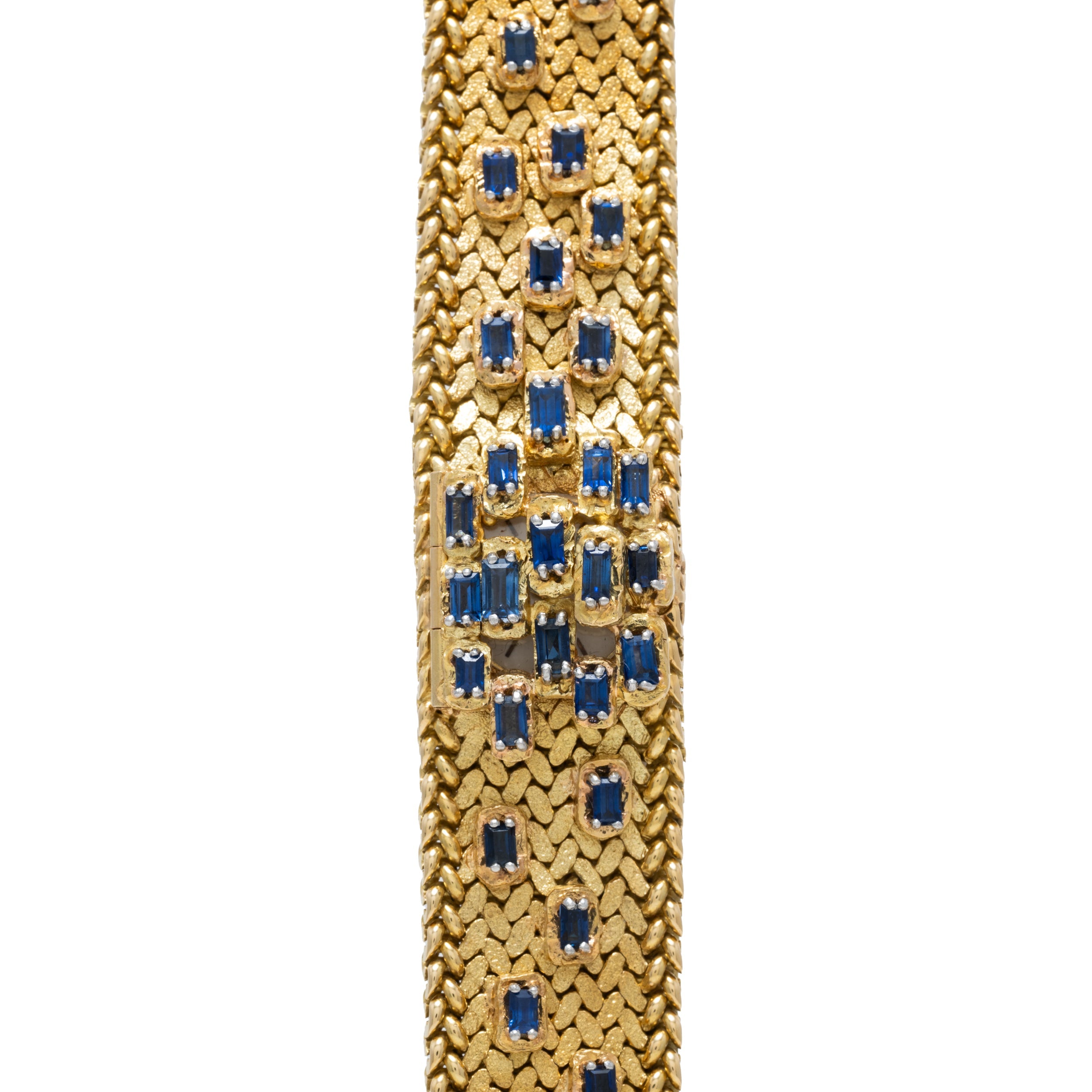 Close-up of the Patek Philippe Yellow Gold Integrated Dress Watch featuring a textured gold band with square blue gemstones set in a geometric pattern.