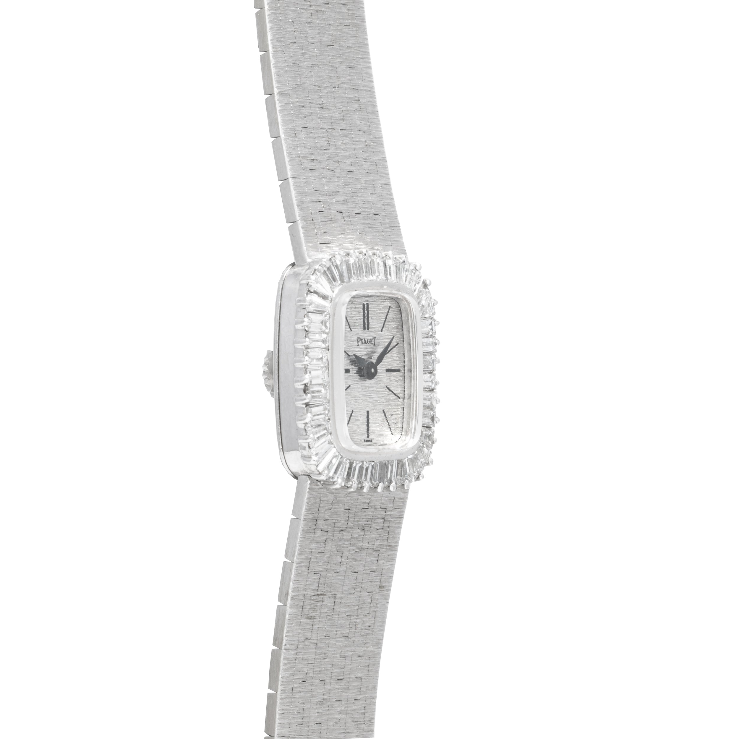 The Piaget White Gold Bark Diamond Dress Watch features a rectangular face, textured band, and a border of clear diamonds, offering luxury in silver-toned white gold.