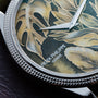 Close-up of a Patek Philippe Calatrava Cloisonné Tropical Leaves II watch face, featuring leaf patterns and silver hands, with the text Patek Philippe Geneve.
