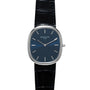 A Patek Philippe Ellipse Jumbo watch with a blue dial, silver markers, and a black leather strap is shown face up.