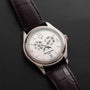 Patek Philippe Annual Calendar Moonphase watch with brown leather strap displayed on black leather.