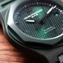 Close-up of the Girard-Perregaux Laureato Green Ceramic Aston Martin Edition watch resting on a wooden surface.