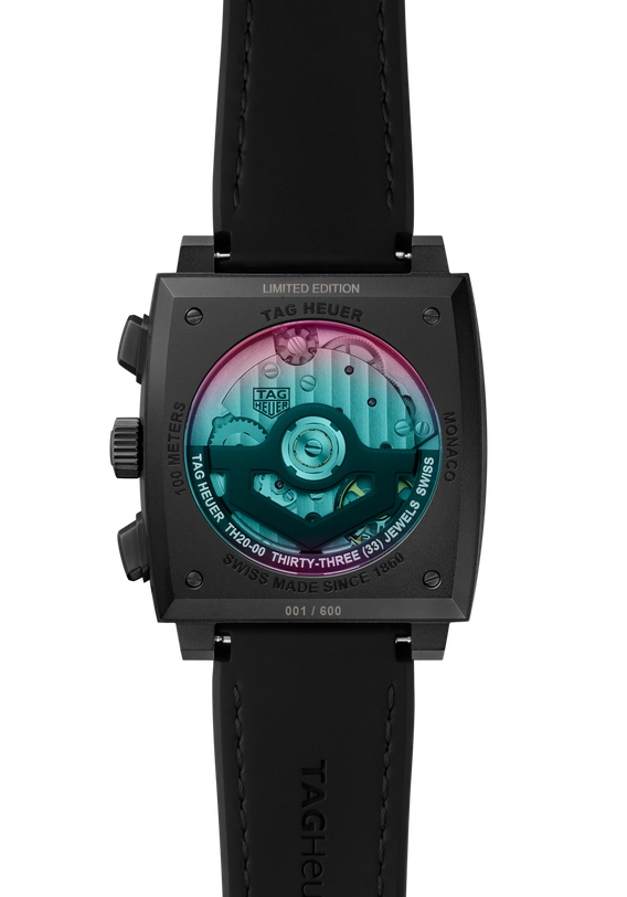 Close-up of the TAG Heuer Monaco Chronograph Las Vegas Edition’s back, showing a transparent case back with visible movement, colorful internals, a titanium DLC-coated case, and engraved serial number on the black strap.