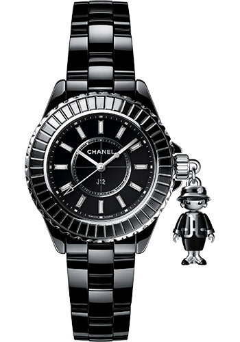 The Chanel Mademoiselle J12 Acte II is a black ceramic watch with a glossy band, silver-edged bezel, diamond accents, and a small metallic charm shaped like a person in a hat and coat attached to the side.