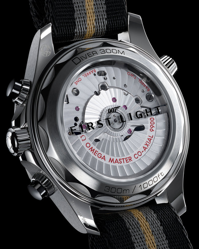 Stainless steel Seamaster Diver 300M chronograph watch with silver dial, red text, and black fabric strap with gold stripe.