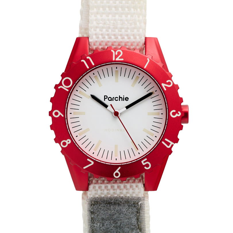 The Parchie Lunar-Time Limited Editions for Hodinkee 36 features a red bezel, white dial, and white strap with the Parchie brand name displayed.