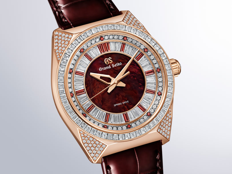 Rose gold watch with deep red dial, diamond-set bezel and lugs, baguette and round stone hour markers, burgundy leather strap