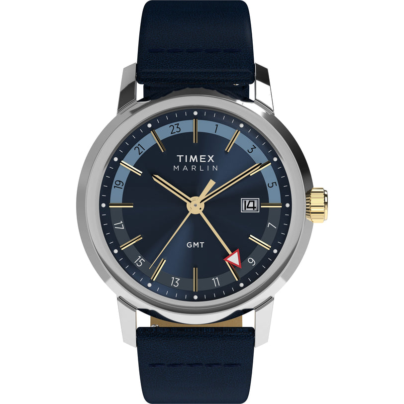 The Timex Marlin® Quartz GMT features a domed acrylic crystal, dark blue dial, gold-tone hands and markers, date at 3 o’clock, black leather strap, and a red-tipped GMT hand for tracking a second time zone on the inner 24-hour ring.
