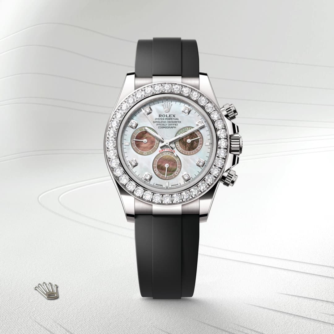 A luxury Rolex watch with a diamond bezel, black strap, and a white mother-of-pearl dial.