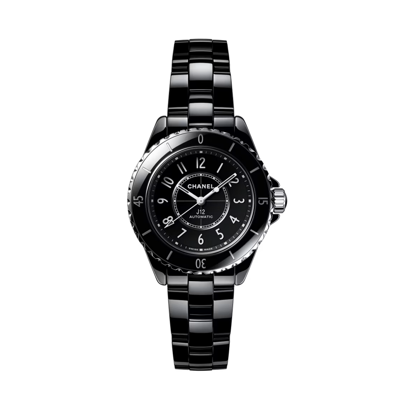 The Chanel J12 wristwatch features a round black ceramic and steel case, Arabic numerals, and a polished link bracelet, shown against a plain white background.