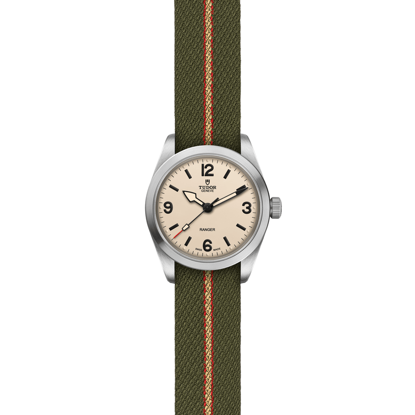 The TUDOR Ranger wristwatch features a cream dial with black numerals and markers, a stainless steel case, and a green fabric strap with red and beige stripes—ideal as an expedition watch.