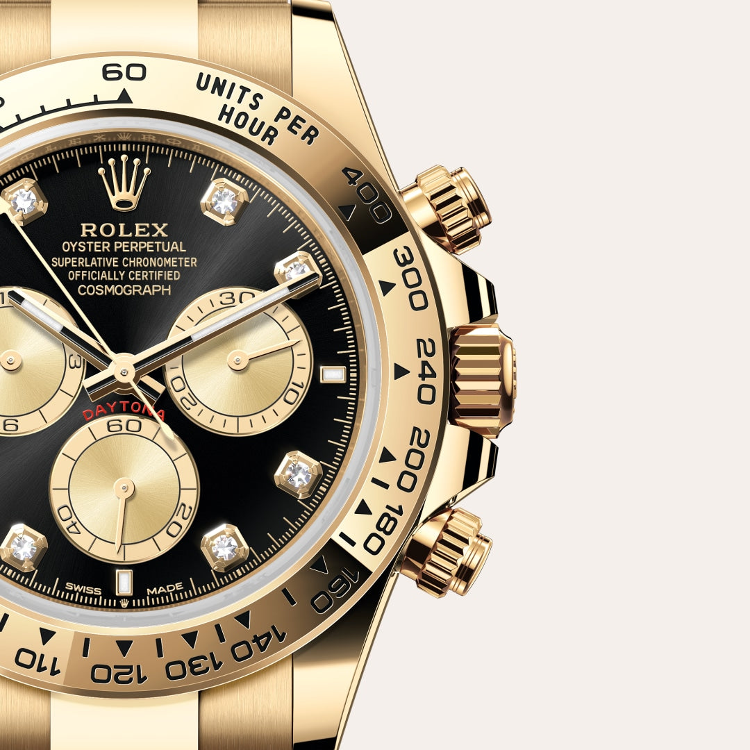 Close-up of a gold Rolex Cosmograph Daytona watch with a black face and diamond hour markers.