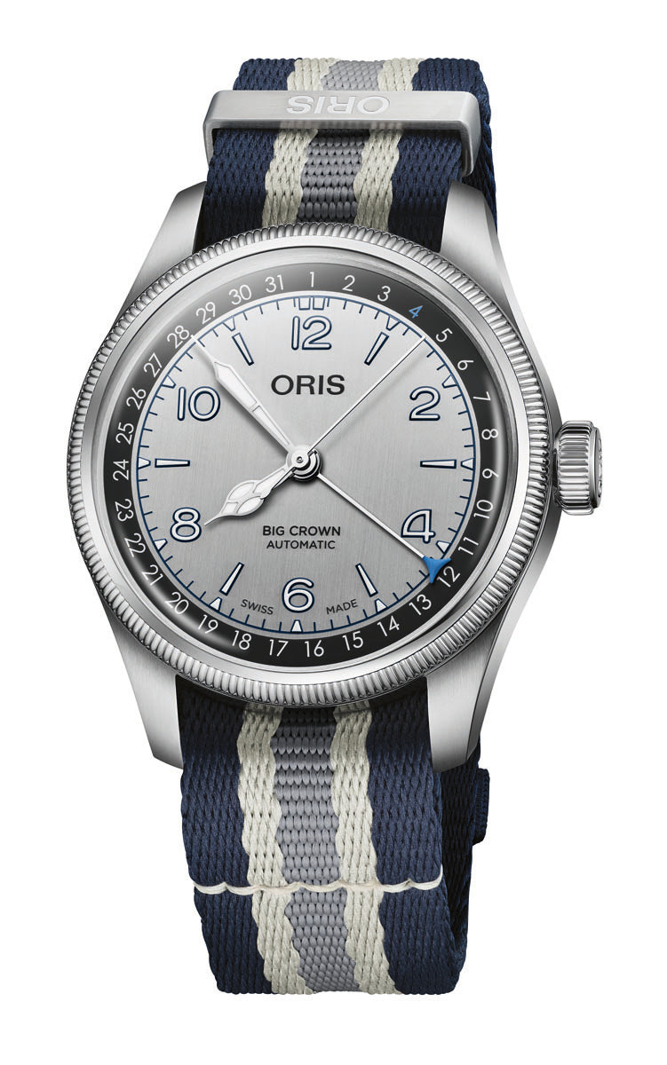 Oris Big Crown Automatic watch with silver dial, numbered bezel, and navy blue striped fabric strap.
