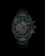 Black sport watch with green bezel, skeleton dial showing exposed gears, luminous hands and hour markers, and metal bracelet.