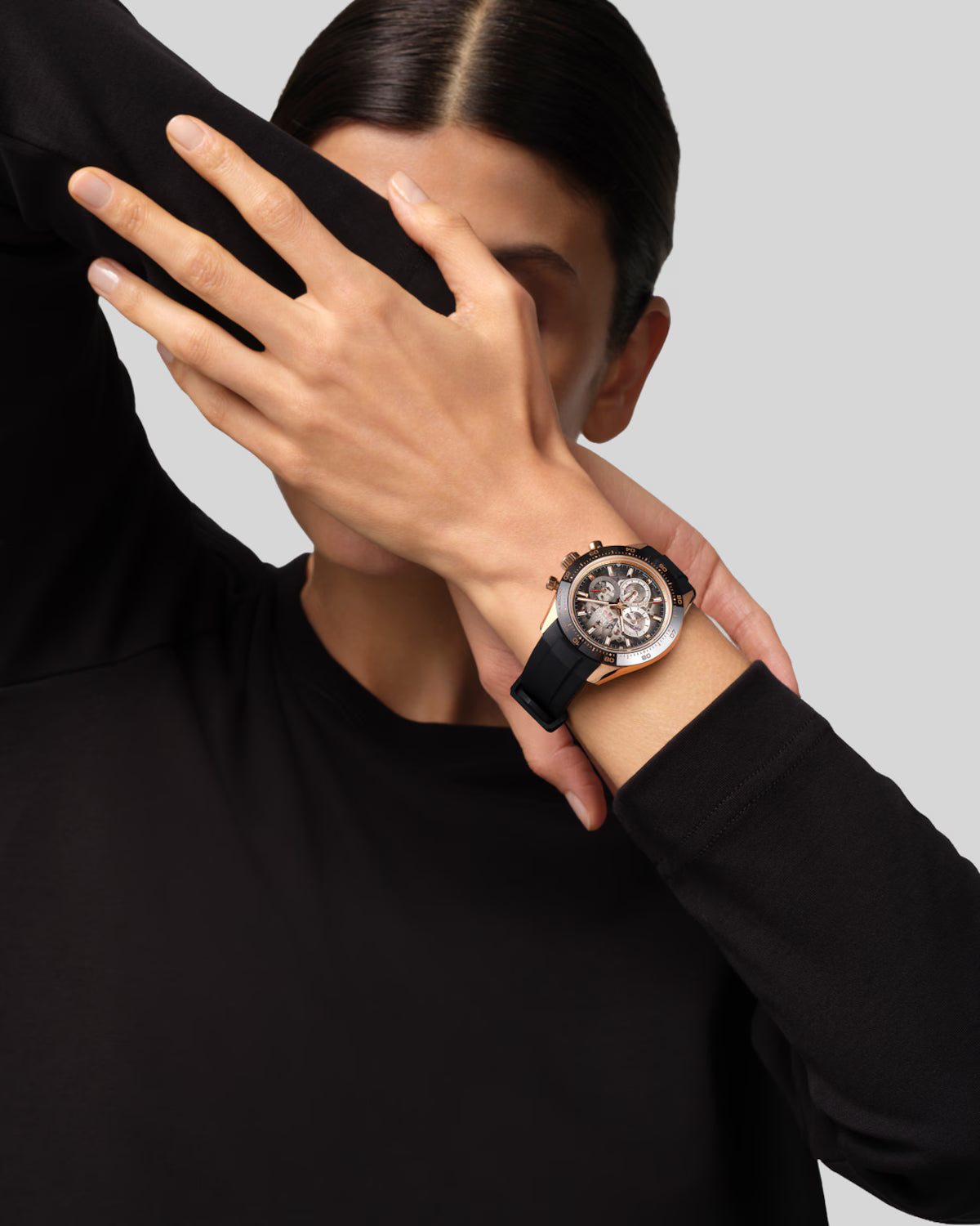 Chronograph watch with white dial, black rubber strap, and metallic bezel worn on wrist.