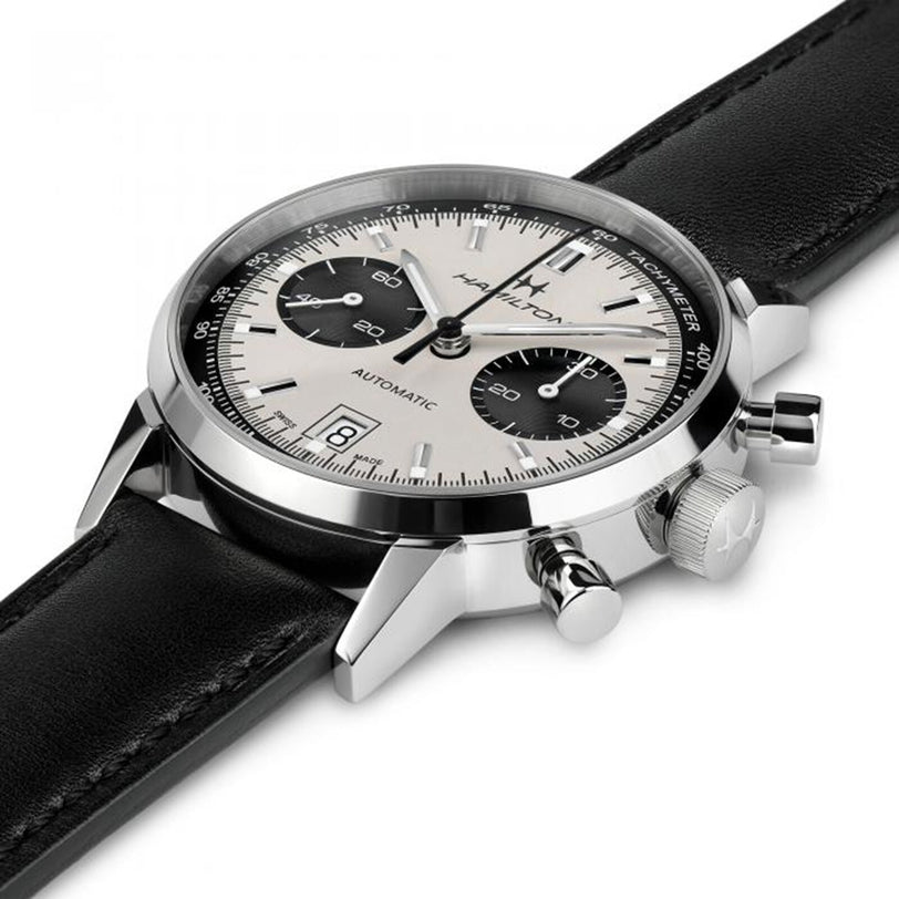 The Hamilton American Classic Intra-Matic Auto Chrono is a silver and black chronograph wristwatch featuring a leather strap, date display, and three subdials.