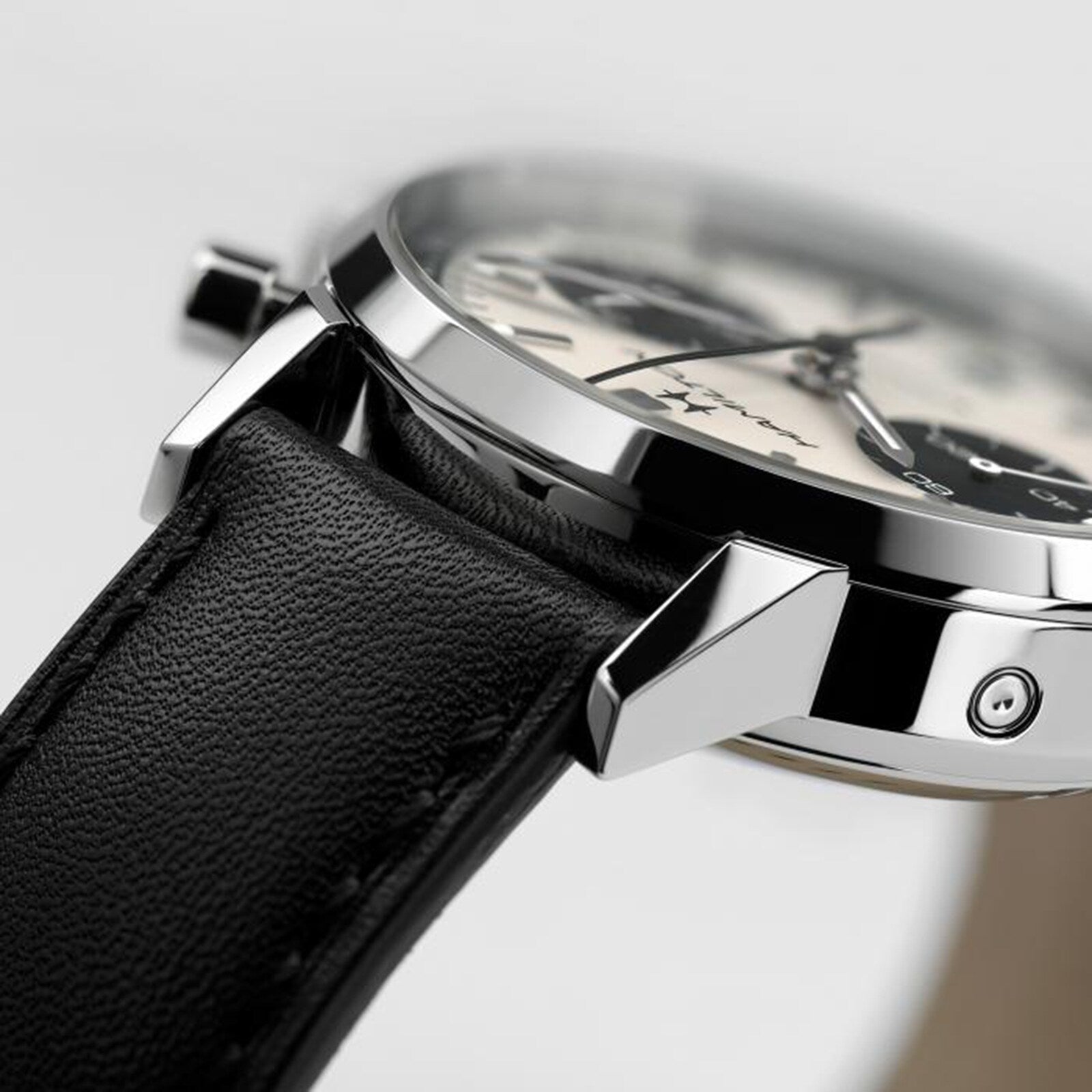 Close-up of the Hamilton American Classic Intra-Matic Auto Chrono wristwatch, featuring a black leather strap, silver case, and a partial view of the dial and lugs.