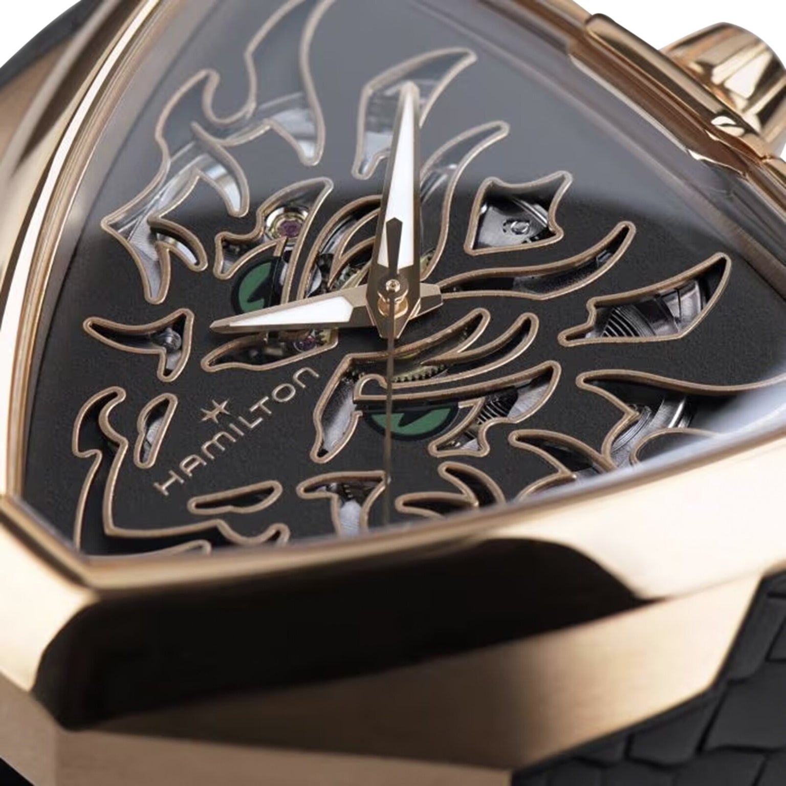 Close-up of the Hamilton Khaki Field King Auto watch featuring a gold case and a black, triangular face with a flame-like skeleton design.