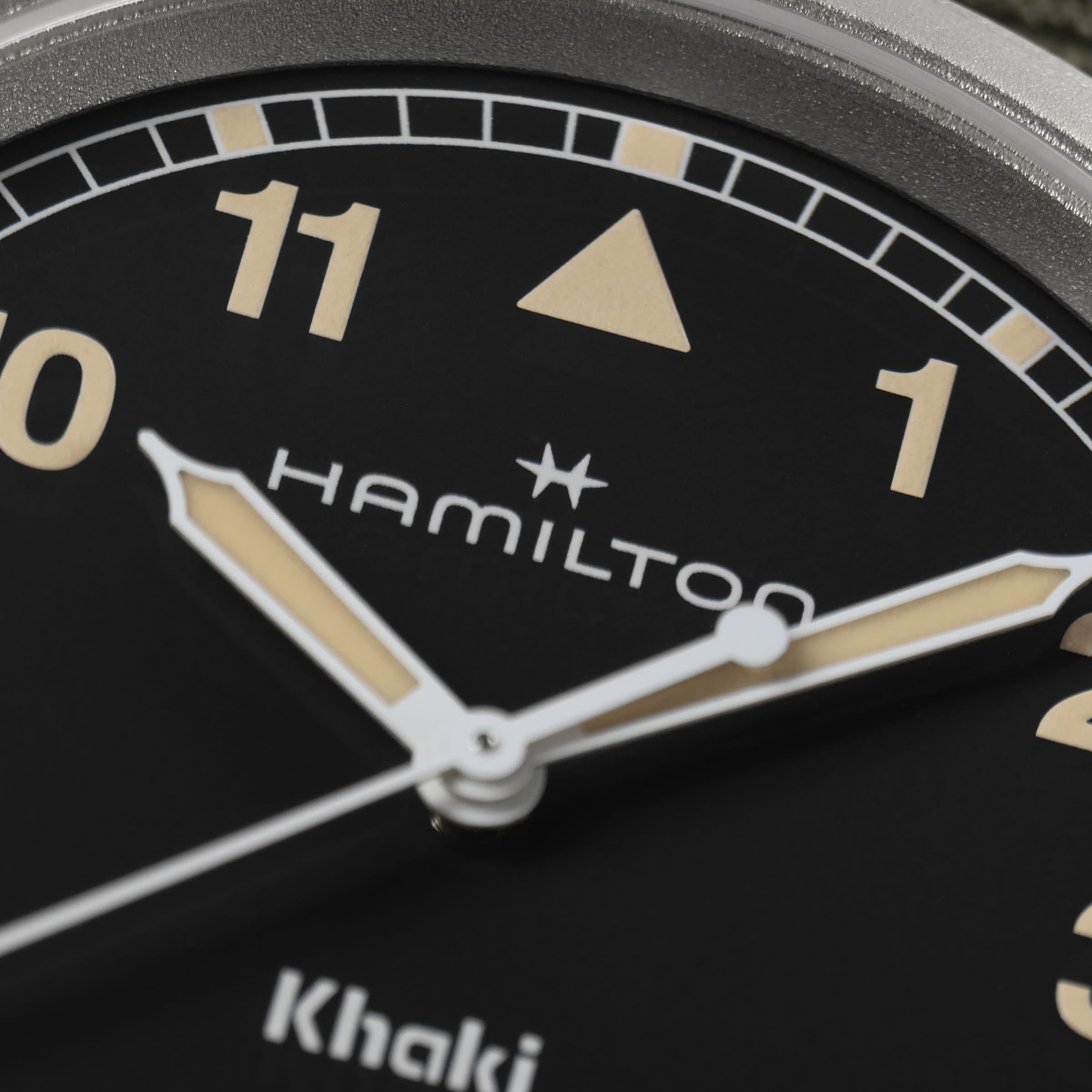 Close-up of the Hamilton Khaki Field Quartz watch face, displaying the logo, hands, and numbers 10, 11, and 1.
