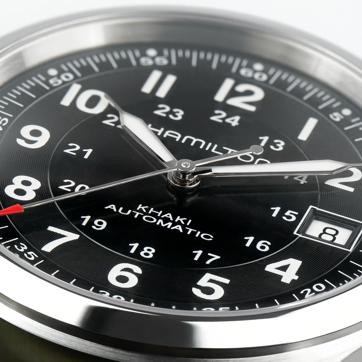 Close-up of the Hamilton x Call of Duty Black Ops 7 watch: Swiss-made, 38mm face, bold white numerals, hour and minute hands, red-tipped seconds hand, date window at 3 o'clock on a black dial with stainless steel bezel.