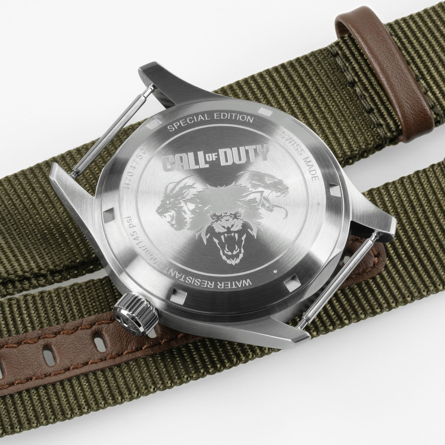 The back of the Swiss-made Hamilton x Call of Duty Black Ops 7 watch features a snarling wolf engraving and Special Edition label, set on an olive green fabric strap with brown leather accents.