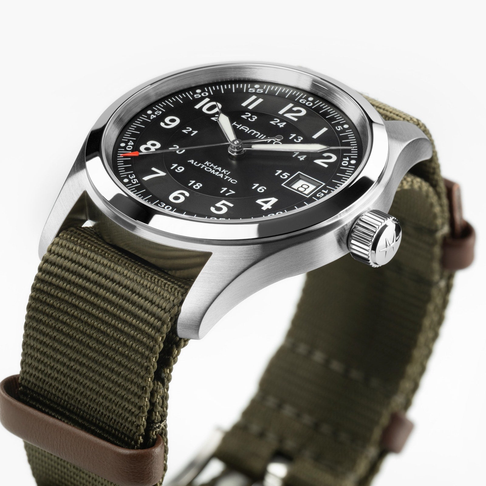 A close-up of the Hamilton x Call of Duty Black Ops 7 wristwatch featuring a black dial, white numerals, date display, stainless steel case, olive green fabric strap, and brown leather accents.