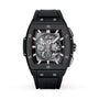 The Hublot Spirit of Big Bang Chronograph Black Magic is a black, rectangular luxury watch with a skeleton dial, red accents, visible gears, metallic bezel screws, black ceramic case, and black rubber strap.