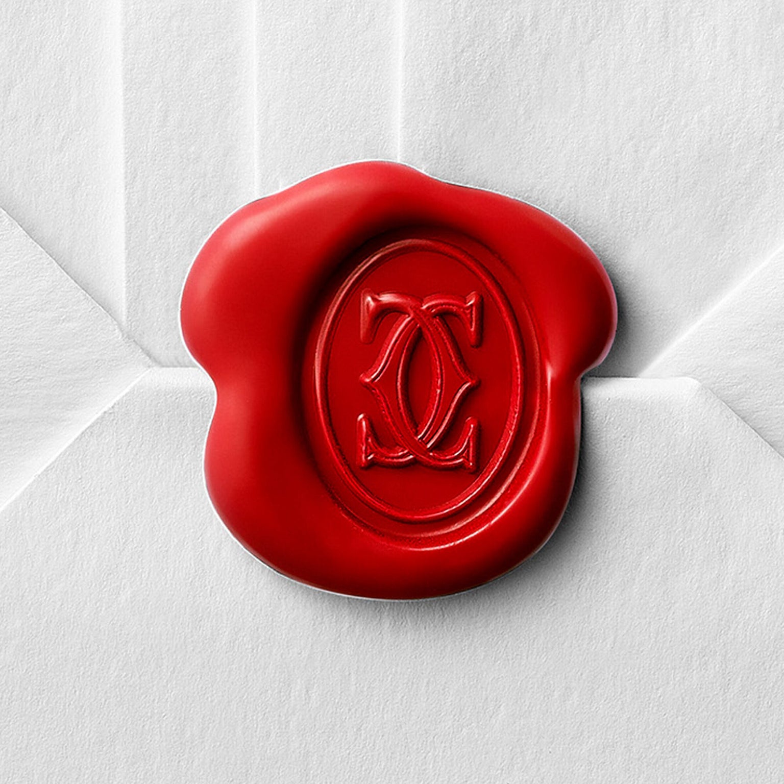 A red wax seal featuring Cartier’s interlocking double C monogram adorns a white envelope, inspired by the Tank Américaine.
