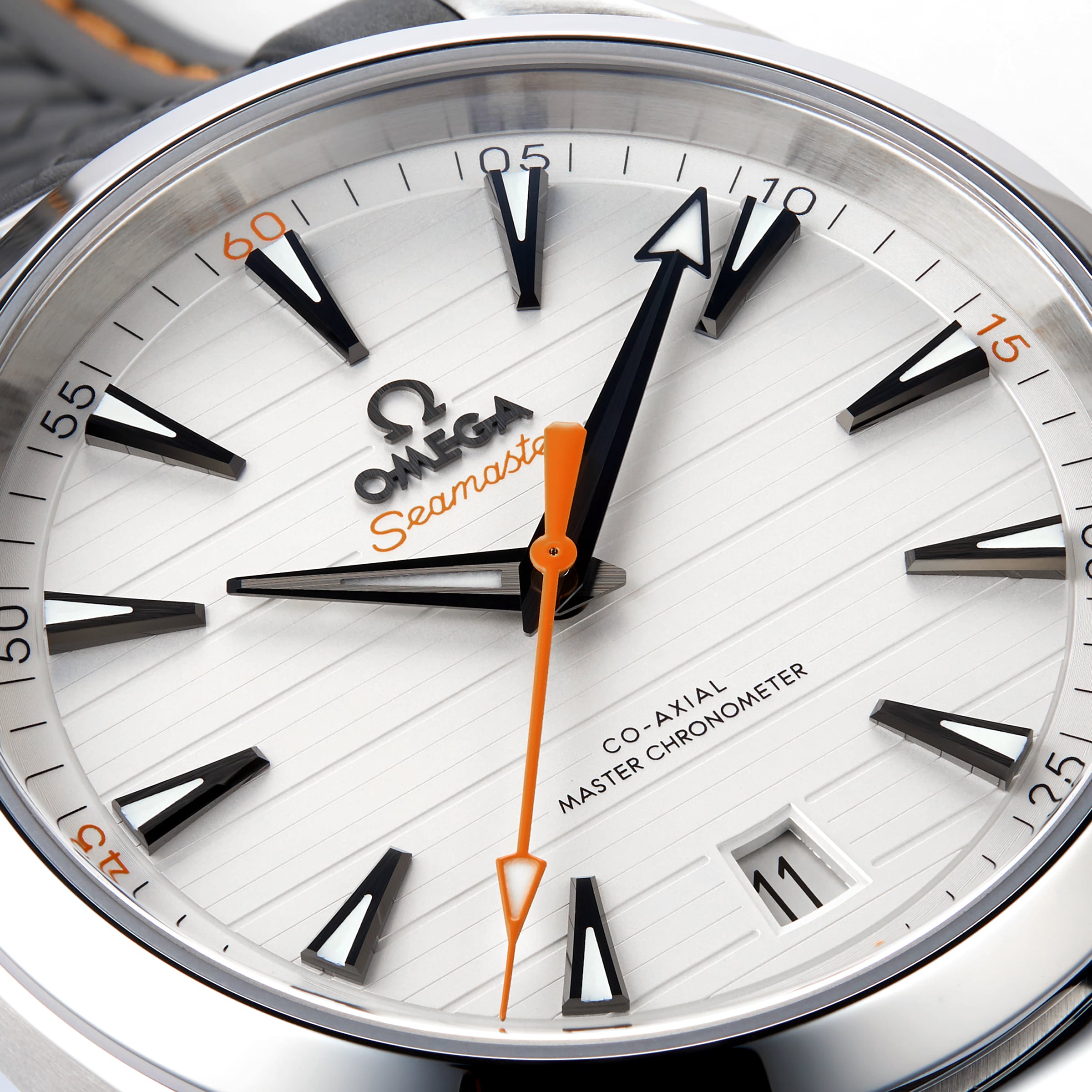 Close-up of an OMEGA Seamaster Aqua Terra 150M watch face with black hour markers, an orange seconds hand, and date set to 11. The dial features Co-Axial Master Chronometer, showcasing its precise calibre 8900 movement.