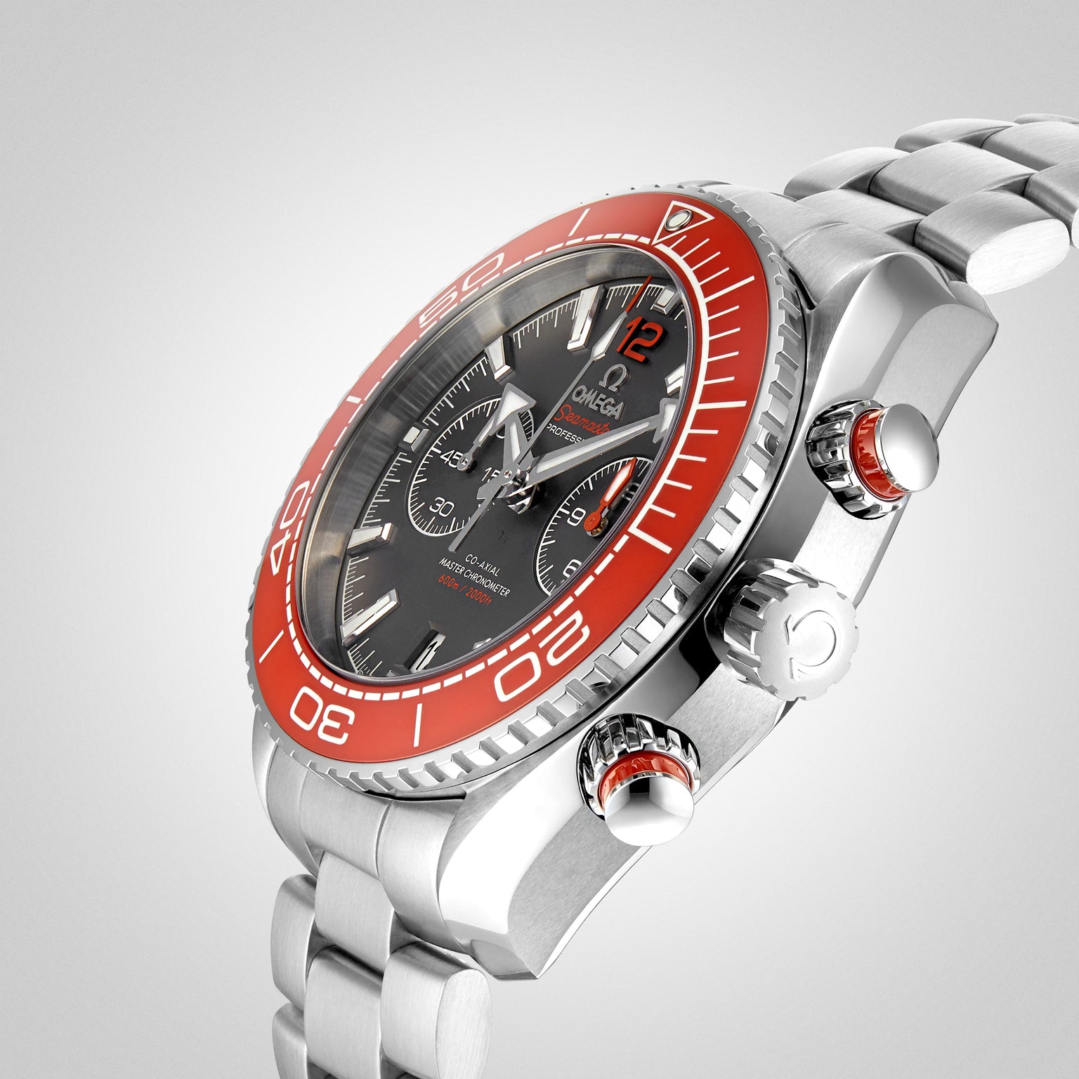 The OMEGA Seamaster Planet Ocean 600M, featuring a stainless steel case, red bezel, black dial, and chronograph powered by the 9900 calibre, is angled on a gradient gray background highlighting its iconic design.