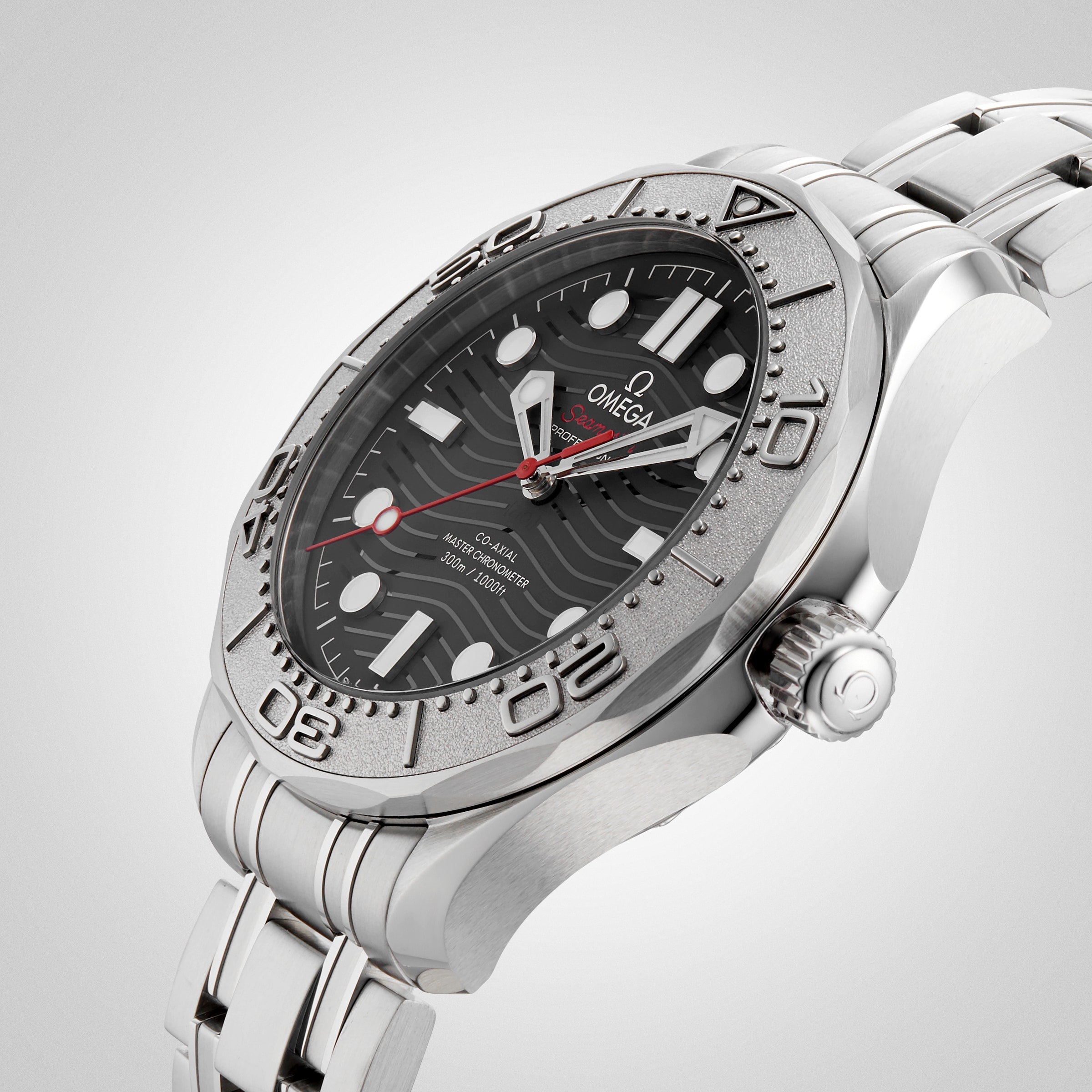 The OMEGA Seamaster Diver 300M Nekton Edition, featuring a stainless steel case, black ceramic wave-pattern dial with large white indexes, date window, and steel bracelet, is displayed on a light background.