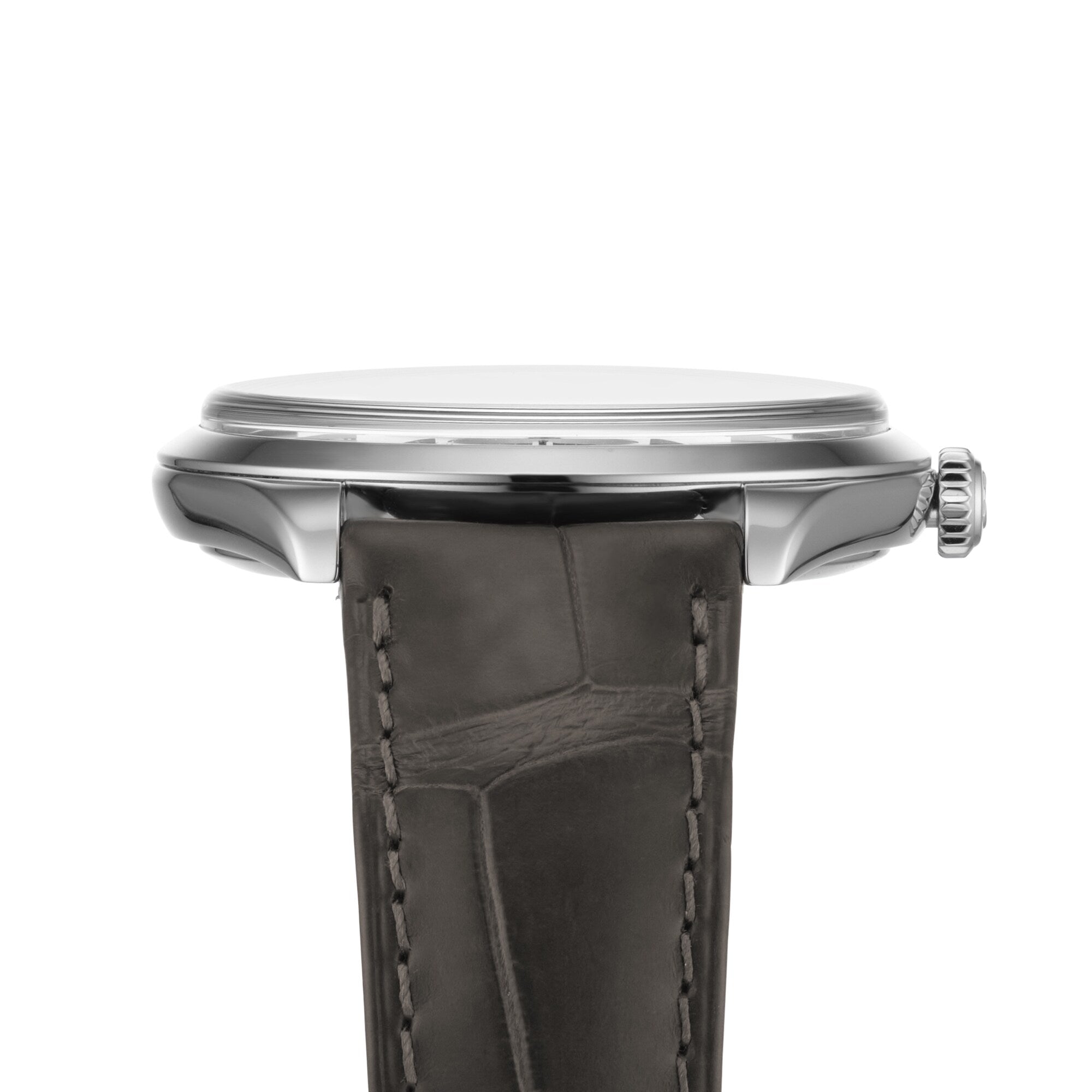 Side view of the OMEGA De Ville Trésor wristwatch with a slim stainless steel case, right-side crown, and dark textured leather strap. This elegant timepiece is Master Chronometer certified.