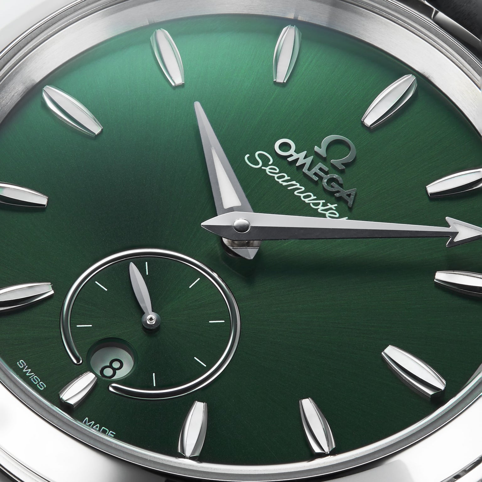 Close-up of a green OMEGA Seamaster Aqua Terra 150M watch face with silver hour markers, hands, sub-dial at 6 o’clock, date window, and powered by the precision 8802 calibre movement.