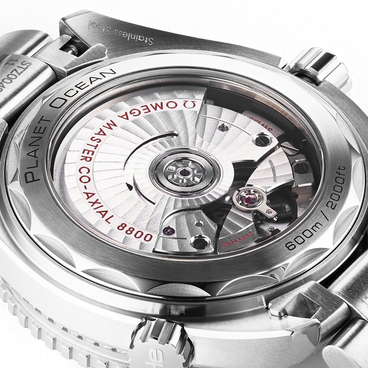 Close-up of the back of the OMEGA Seamaster Planet Ocean 600M, revealing the Master Chronometer 8800 movement through a transparent case back, with visible inscriptions and a hint of the white ceramic bezel.
